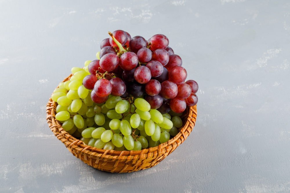 Grapes basket with red, black and green grapes.